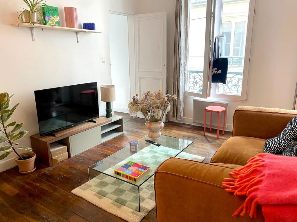 un salon avec un canapé et une table basse en verre dans l'établissement Paris Montmartre sacré coeur, à Paris