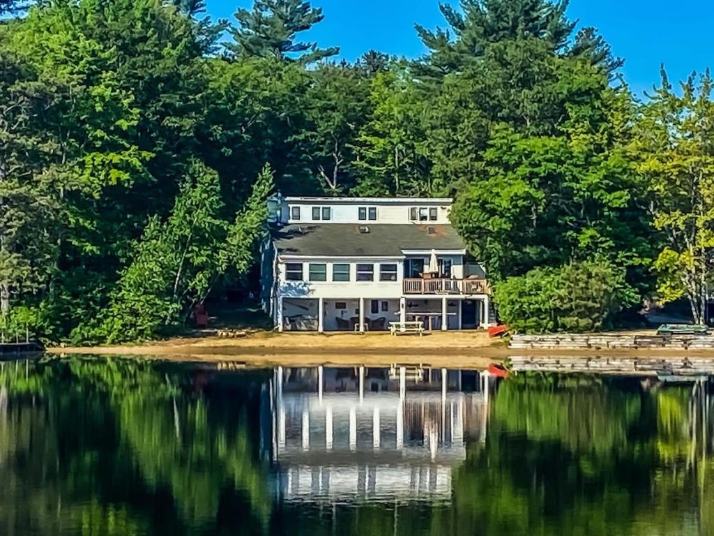 ein großes Haus am Ufer eines Sees in der Unterkunft Lake Home with Private Beach and Hot Tub in Ossipee