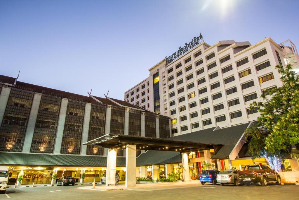 a hotel with a parking lot in front of a building at Chiang Mai Hill Hotel in Chiang Mai