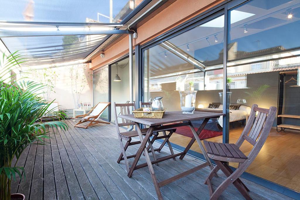 un patio con mesa de madera y sillas en My Space Barcelona Penthouse Terrace en Barcelona