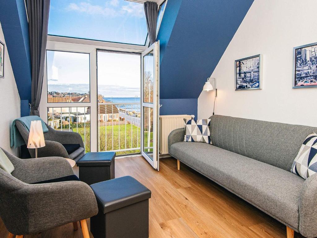 4 person holiday home in Hejls-By Traum في Hejls: غرفة معيشة بها أريكة وكراسي ونافذة كبيرة