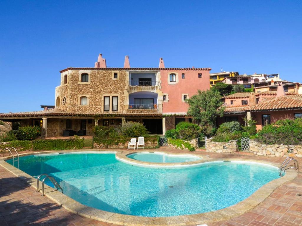 a large swimming pool in front of a building at Apartment La Capitaneria in Porto Cervo