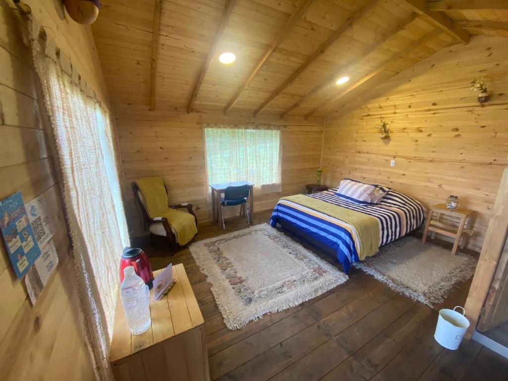 1 dormitorio con 1 cama en una cabaña de madera en Serás Libre Refugio, en Zipaquirá