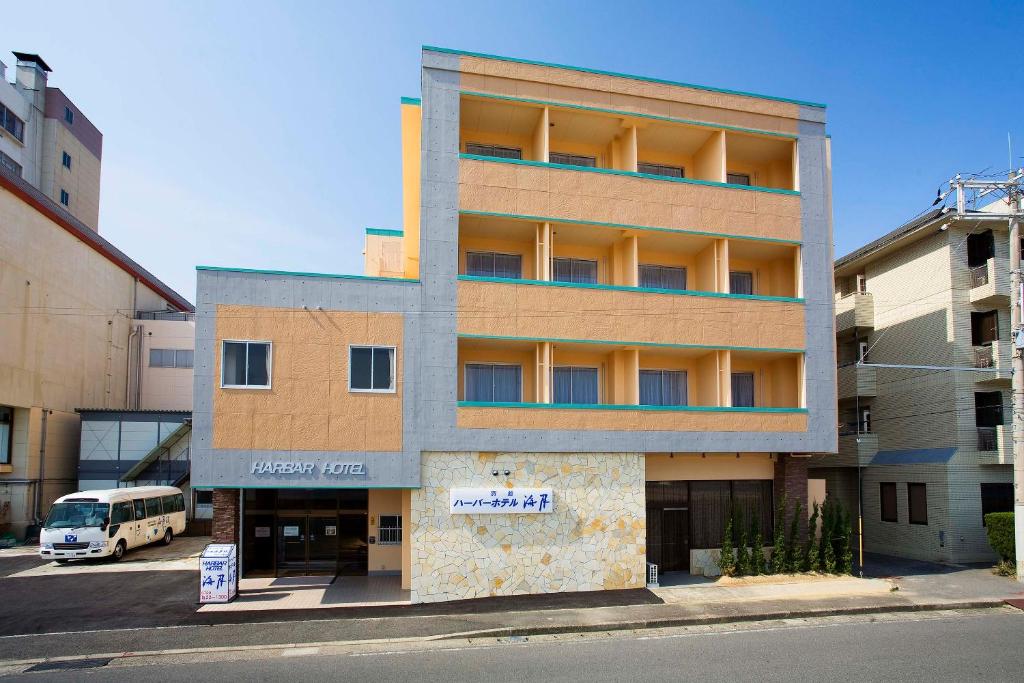un edificio con un autobús estacionado frente a él en Harbor Hotel Kaigetsu en Sumoto