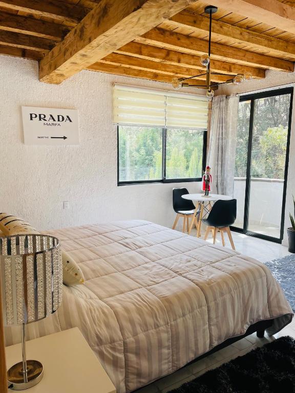 a bedroom with a large bed and a table with chairs at Veta Corona in Tlalpujahua de Rayón
