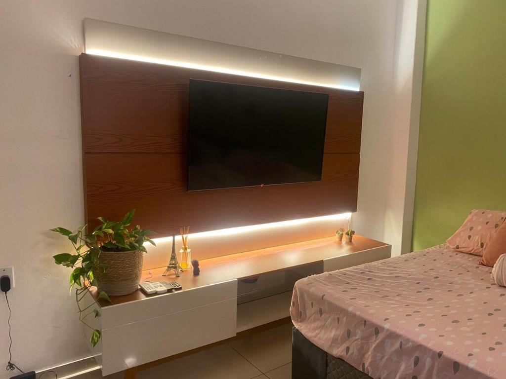 a bedroom with a tv on a wall with a bed at Apartamento em Uruguaiana in Uruguaiana