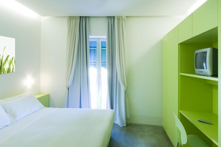 een slaapkamer met een wit bed en een televisie bij Villa Greta in Santarcangelo di Romagna