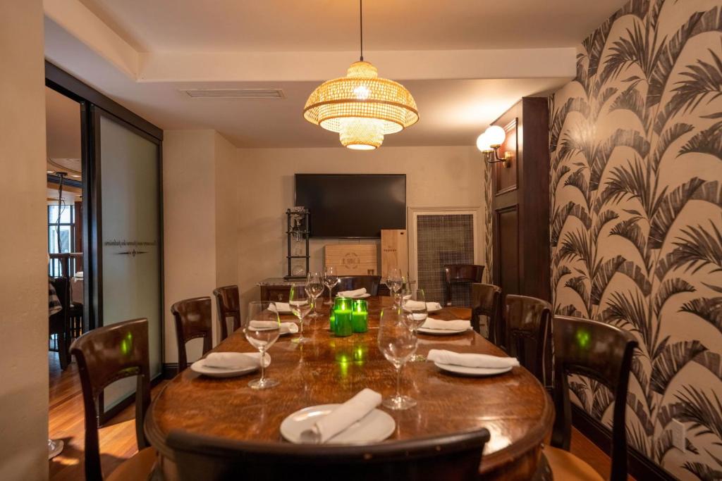 a dining room with a table with chairs and a chandelier at Hotel Le Soleil by Executive Hotels in Vancouver