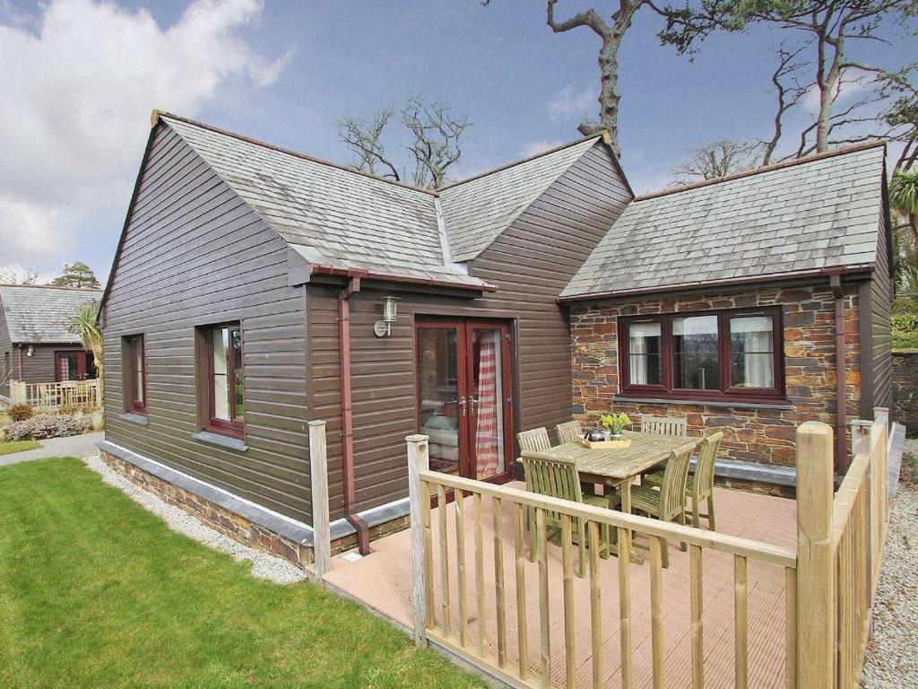 a small house with a table and a fence at 2br-sleeps4-pool-freeparking-trenythonestate in Par