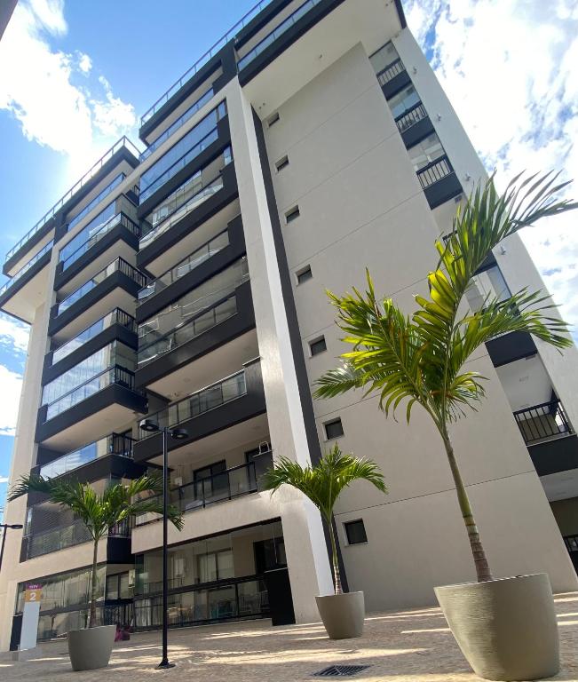 a building with palm trees in front of it at Loft Sou Mais Icaraí in Niterói