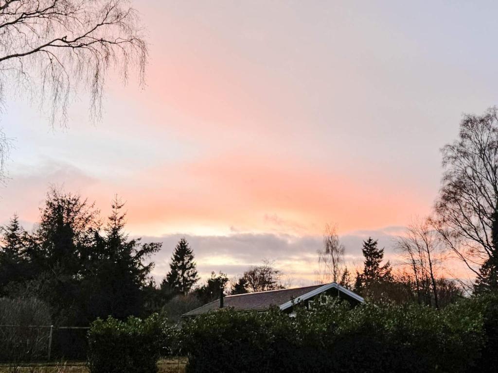 a house with a sunset in the sky at 8 person holiday home in Holbæk in Holbæk