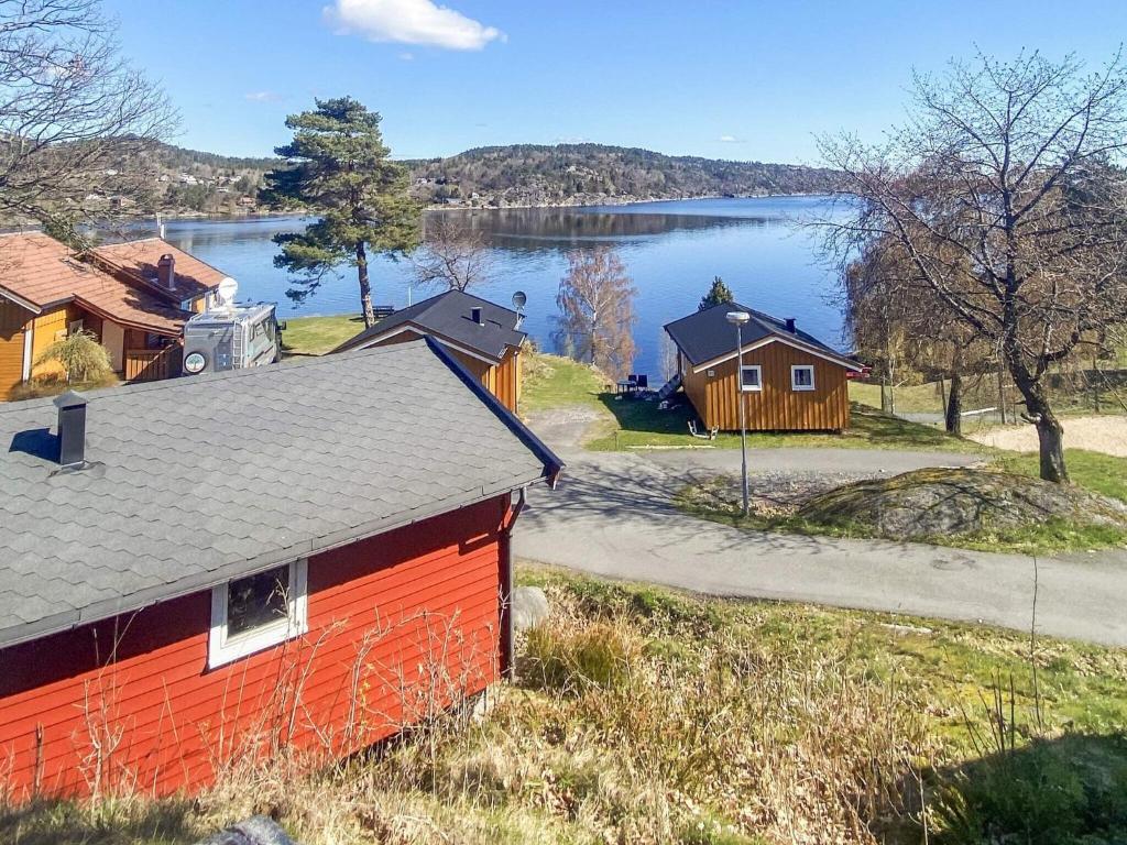 a red house with a lake in the background at 4 person holiday home in Risør in Risør