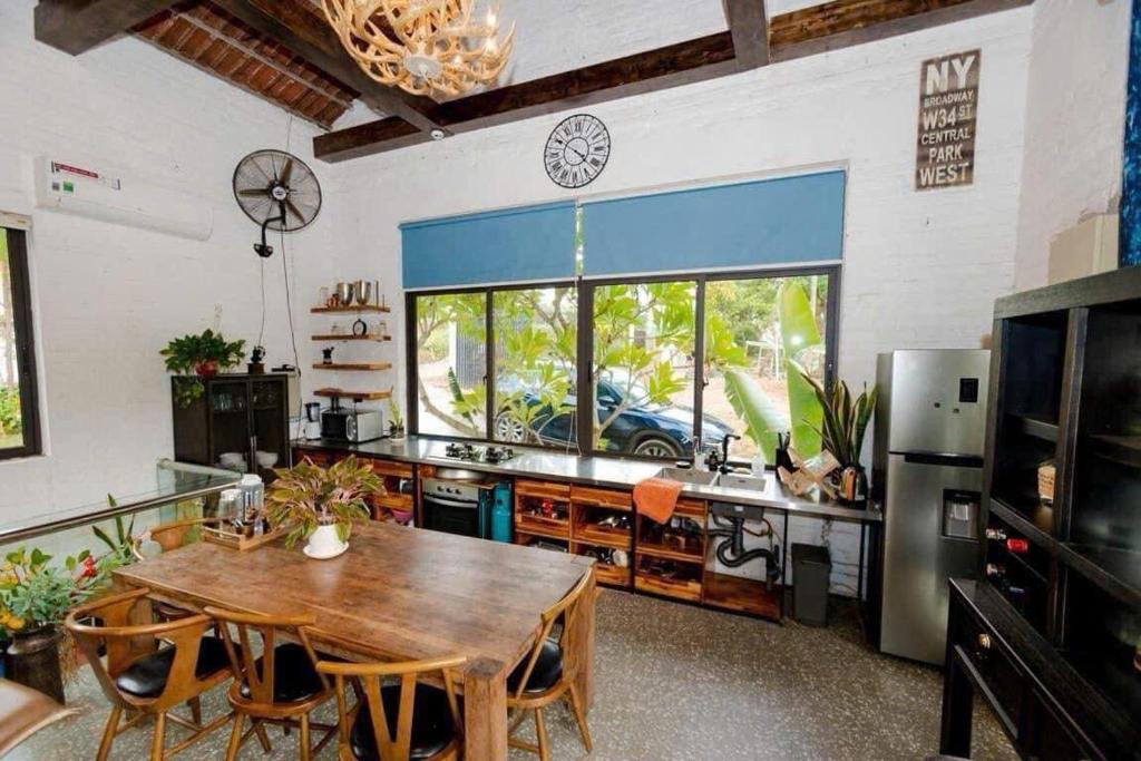a kitchen with a table and a large window at Lavita villa Resort in Sóc Sơn