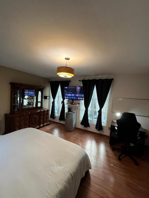 a bedroom with a bed and a desk and windows at SúperAnfitrión Coyoacán King 1 in Mexico City