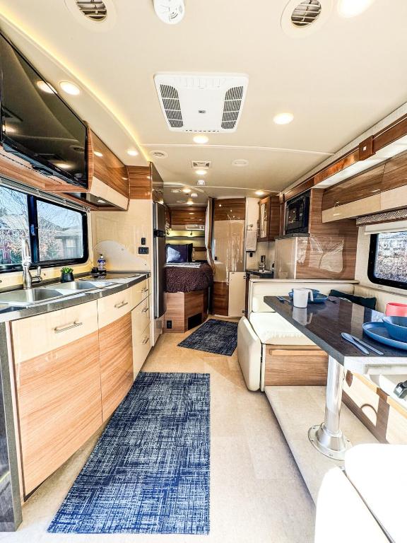 an rv kitchen with a sink and a table at Navi- HUGE yard- MEGA playset- CUTE RV in Willmar