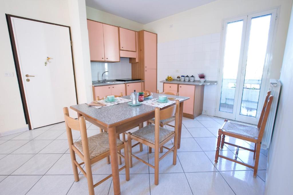 eine Küche mit einem Holztisch und 2 Stühlen in der Unterkunft Orchidea Pineto Vacanza in Pineto