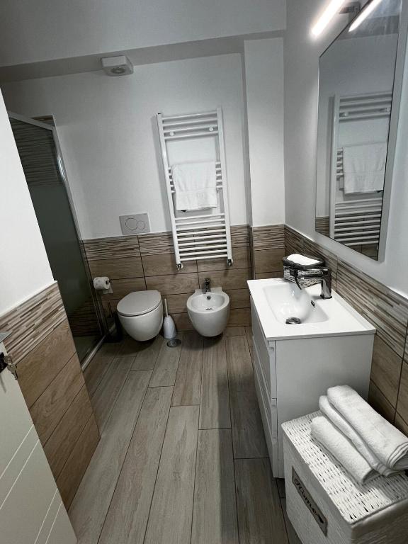 bagno con lavandino, servizi igienici e specchio di Elegant & Spacious 2BR 2BA Unit with Private Patio a Roma