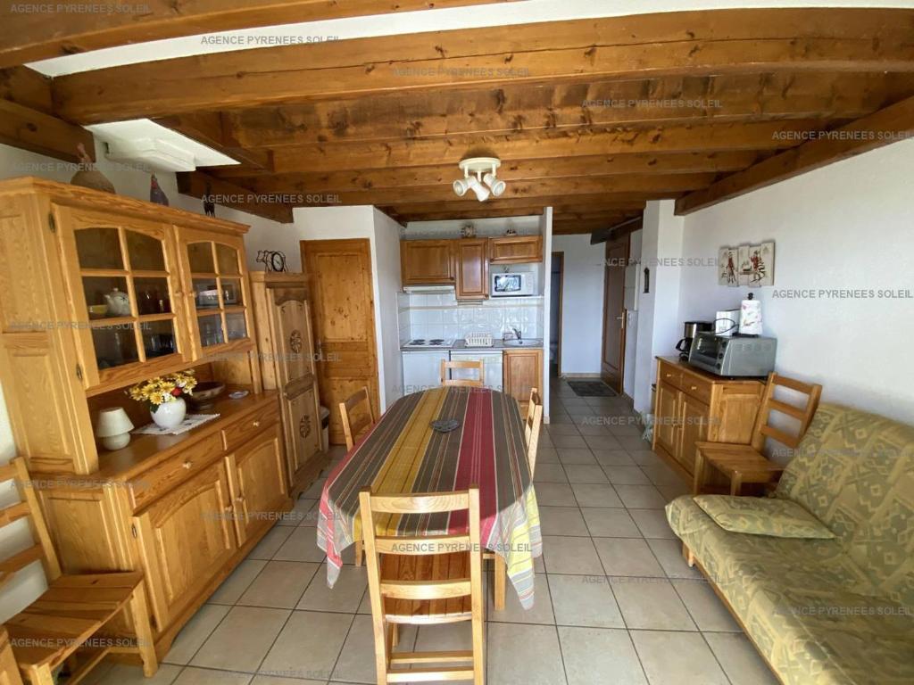 une cuisine avec une table et des chaises dans une pièce dans l'établissement Appartement T4 tout équipé - 6 couchages - Les Angles - FR-1-295-164, aux Angles