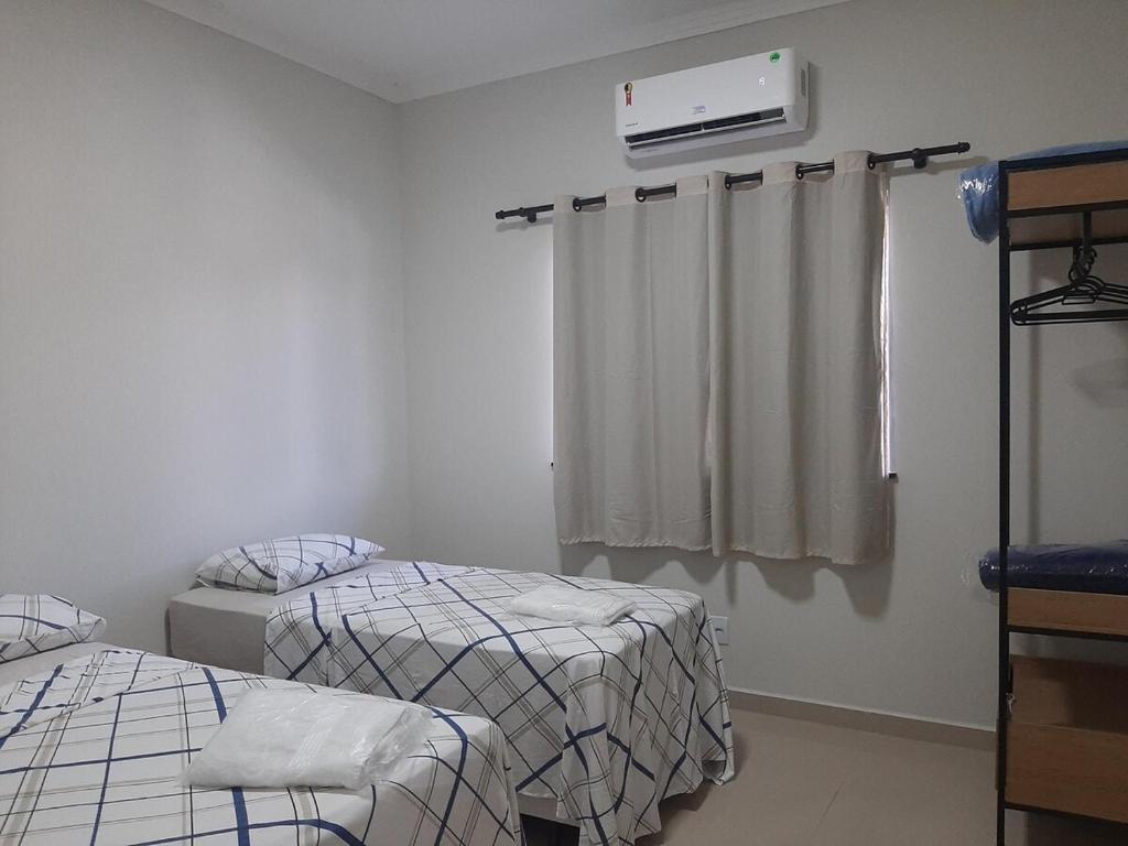 ein Krankenzimmer mit zwei Betten und einem Fenster in der Unterkunft Residencial Reis - Cozy and Comfortable Apto in Boa Vista