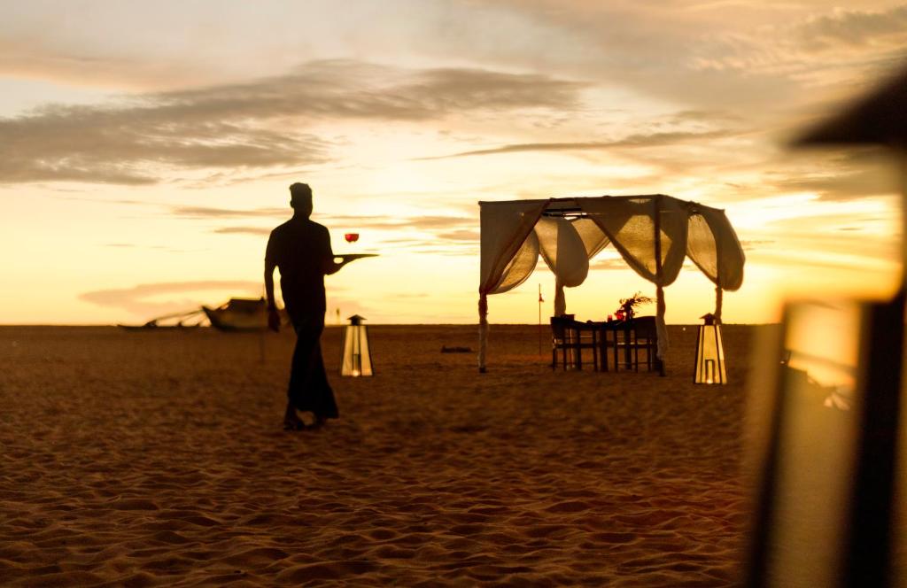 a man standing on the beach with a frisbee at Jetwing Beach in Negombo