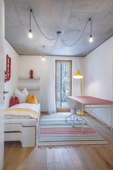 a bedroom with a bed and a desk and a table at Wohnen in der Villa Kunterbunt nahe der 5-Seen-Landschaft in Puchheim