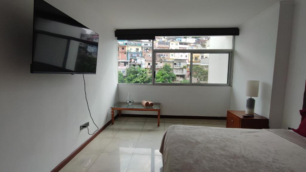 a bedroom with a bed and a large window at Riverfront2 II in Guayaquil