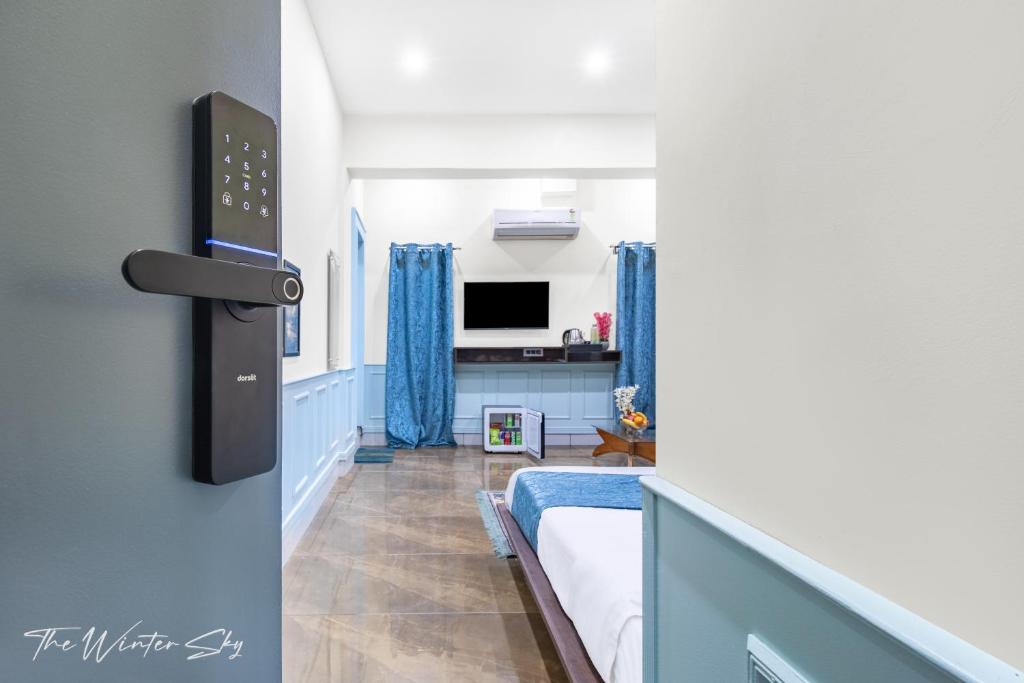シュリーナガルにあるHotel The Winter Skyのベッドとテレビのある部屋