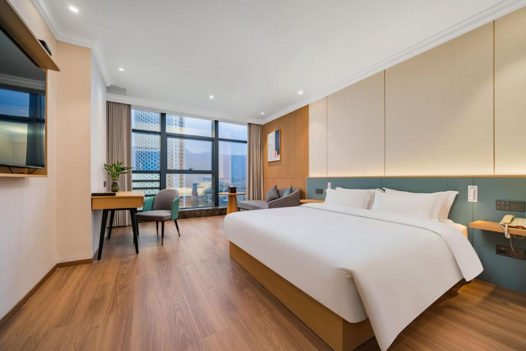 Postel nebo postele na pokoji v ubytování Tonglu City Center Rosery Hotel