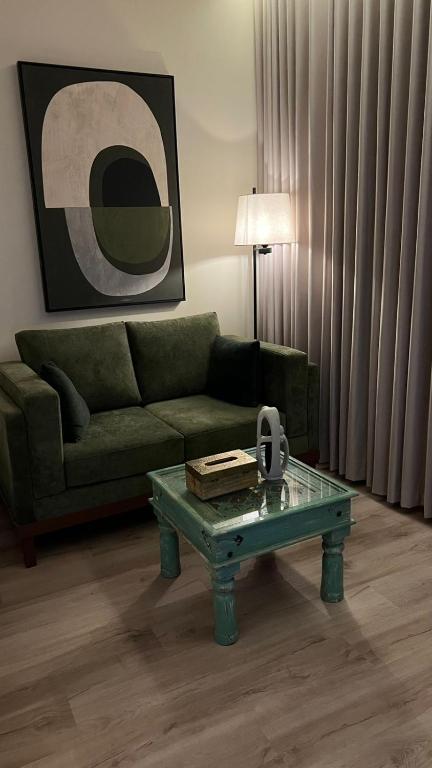 a living room with a green couch and a coffee table at استديو أنيق كلاسيكي in Riyadh