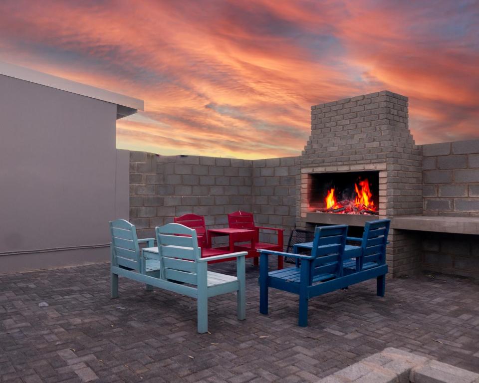 a room with a fireplace with chairs and a fire place at Amberdale Estate Budget Self Catering in Queenstown