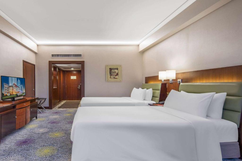 Postel nebo postele na pokoji v ubytování Ramada Plaza Pudong Shanghai