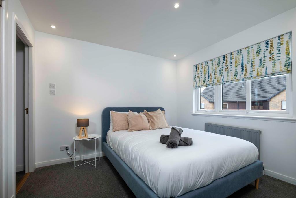 una camera da letto con un letto con un orsacchiotto sopra di LANGLEY HOUSE central LOCATION 5 bed all double with smart TV 3 BATHROOMS Loved by TRADES teams ideal for LONG STAYS contact langley cottages and apartments a Dundee