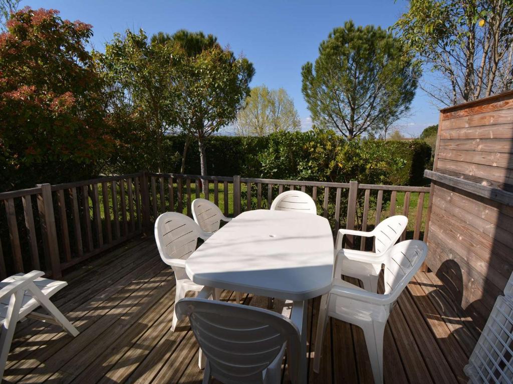 une table et des chaises blanches sur une terrasse dans l'établissement Maison Duplex avec Terrasse - 6 Pers, 4 Pièces, WiFi, Animaux Bienvenus, Parking Inclus - FR-1-382-185, à Grospierres