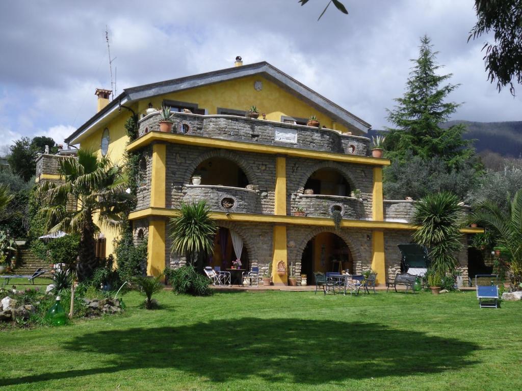 ヴェッレトリにあるLa Culla Dei Castelli Romaniの前方に芝生のある大きな黄色の建物