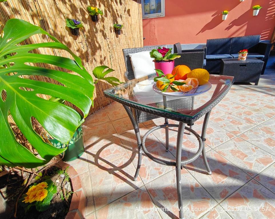 a glass table with a plate of fruit on it at Manù Apartment in Vico Equense