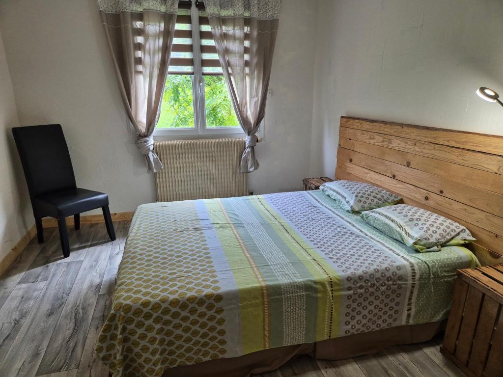 une chambre avec un lit, une chaise et une fenêtre dans l'établissement Gite Perce Neige, à Foncine-le-Haut
