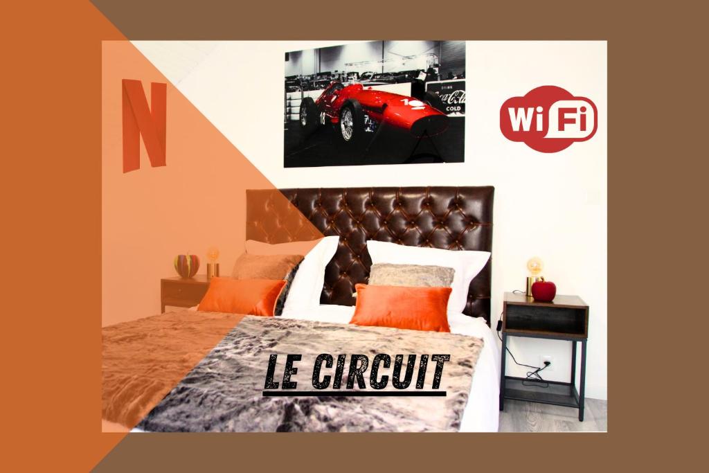 sypialnia z łóżkiem z czerwonym plakatem w obiekcie Le Circuit - Tout simplement: confort! w mieście Cosne-Cours-sur-Loire