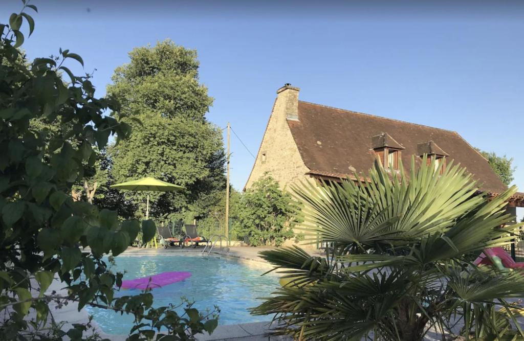 a house with a swimming pool next to a building at Maison pour 6 avec piscine et grand jardin in Plazac