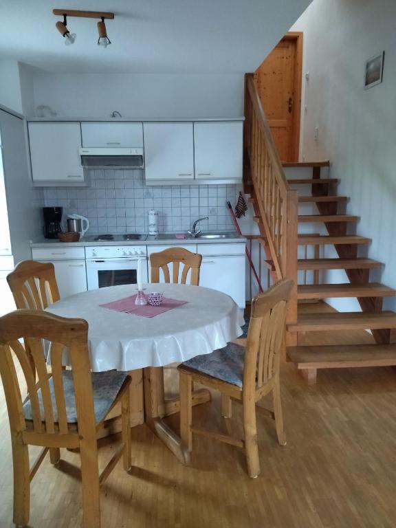a kitchen with a table and chairs and a staircase at Ferienhof Alte Schmiede in Burgpreppach
