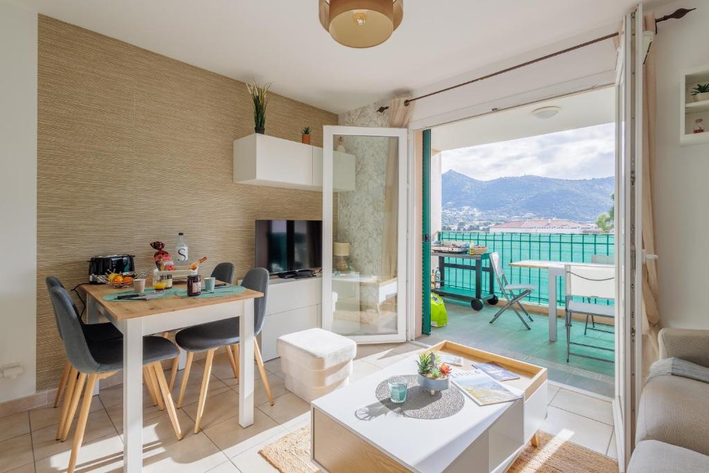 une cuisine et un salon avec une table et des chaises dans l'établissement U Sognu - Proche plage vue montagne, à LʼÎle-Rousse