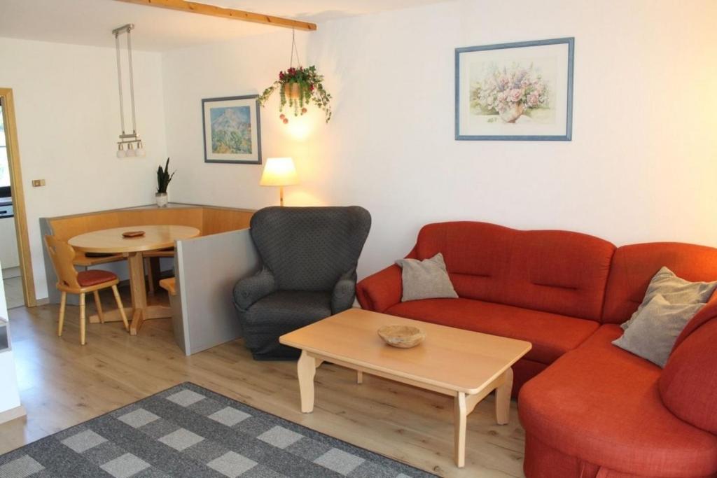 a living room with a couch and a table at Ferienhaus Nr 48, Kategorie Komfort, Feriendorf Hochbergle, Allgäu in Lechbruck