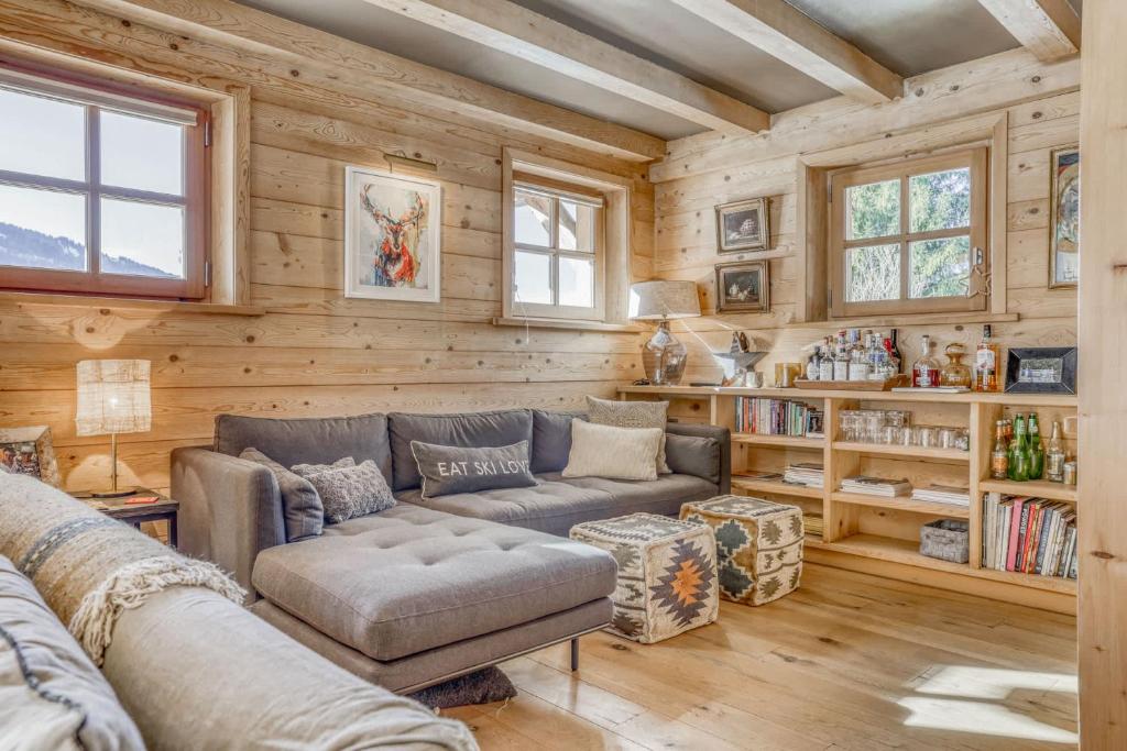 a living room with a couch and wooden walls at Chalet Glisse in Megève