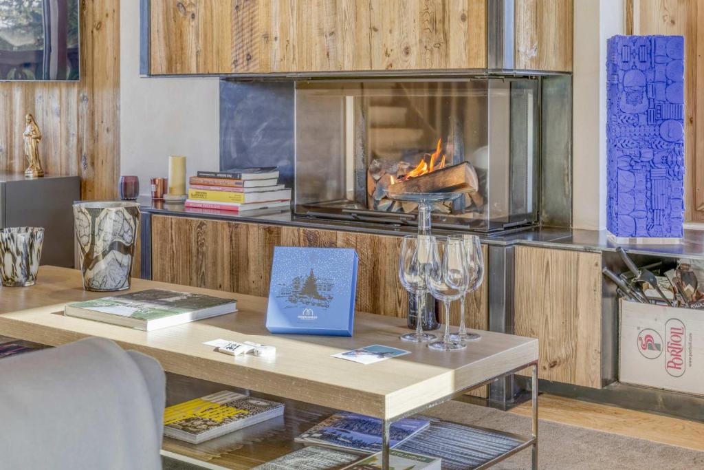 - un salon avec une table et une cheminée dans l'établissement Chalet Alpina, à Megève