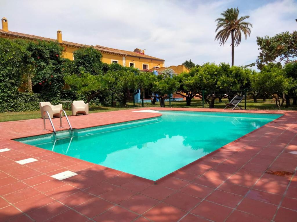 a swimming pool with two chairs and a building at MAS DE BERNIS - Masia in L'Aldea