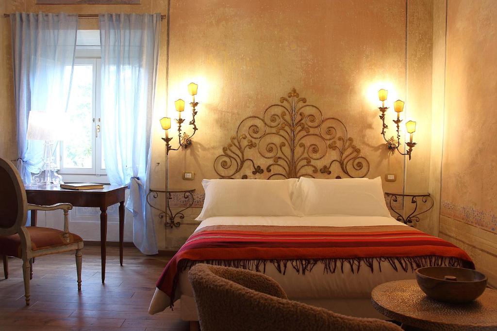 a bedroom with a bed and a desk and a window at Villa Ginori 1755 in Londa