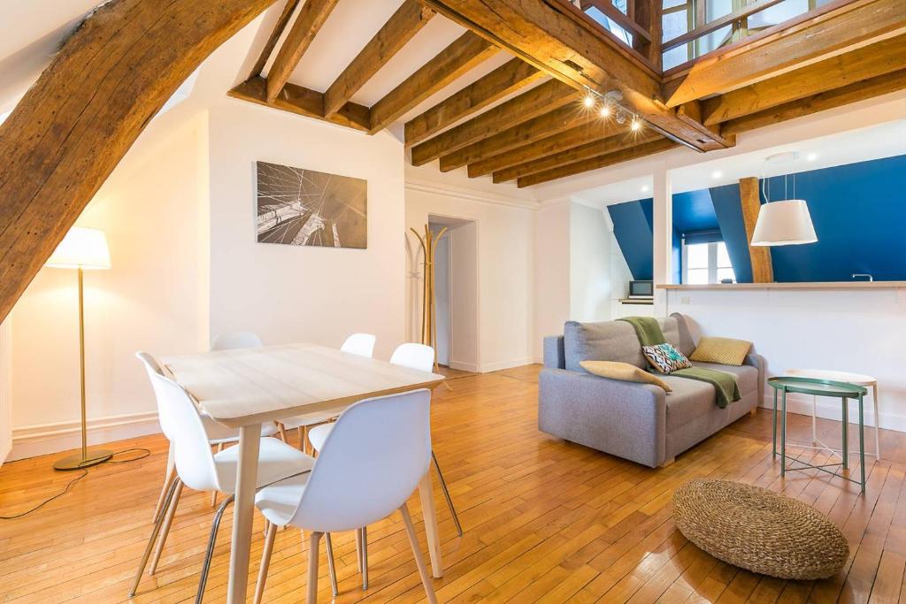 a living room with a table and a couch at LA Plume aux pieds du Parvis Saint Jean in Dijon
