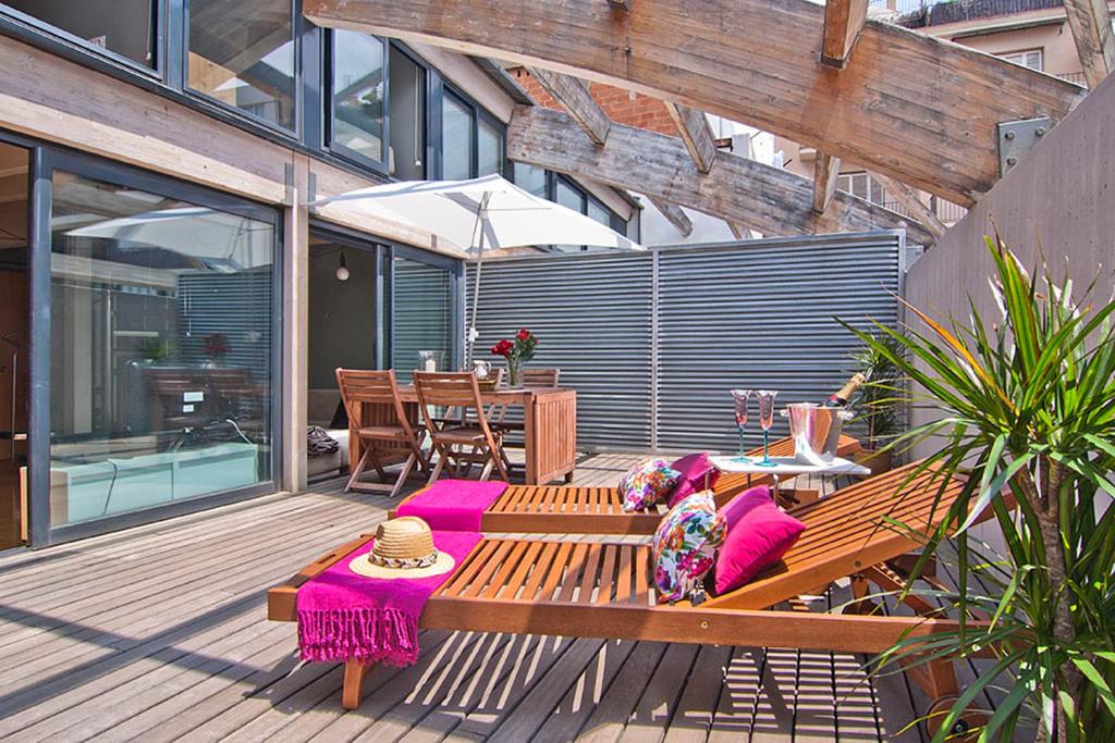 a wooden bench sitting on a deck with a table at My Space Barcelona Executive Apartments Center in Barcelona