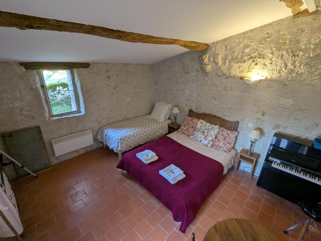 - une petite chambre avec un lit et un piano dans l'établissement Le Sabathe, à Saint-Mézard