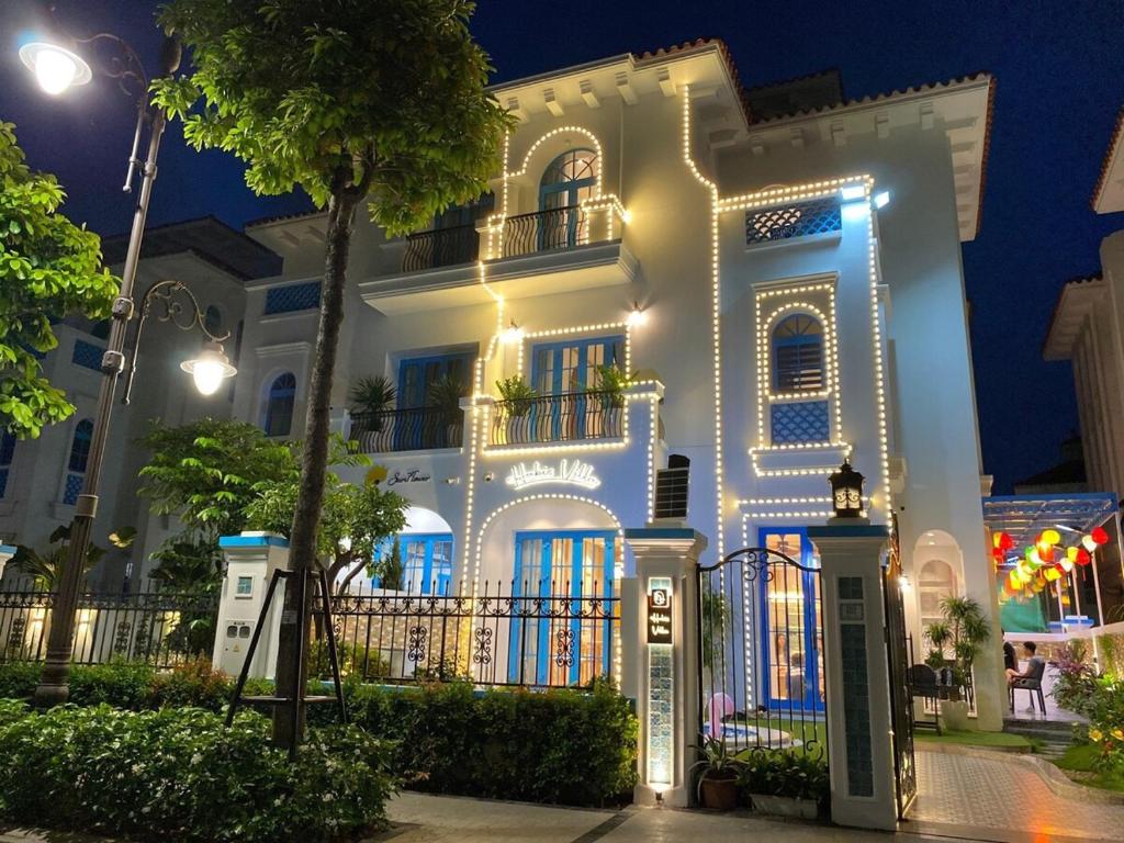 une maison blanche avec des lumières allumées la nuit dans l'établissement HT Sea Villa - 7 Bed Rooms, à Hạ Long