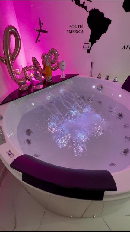 a bath tub in a room with a pink wall at G-house in Parma